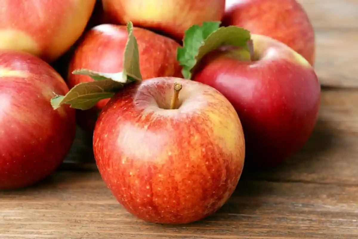 Красные яблоки на деревянном столе фото