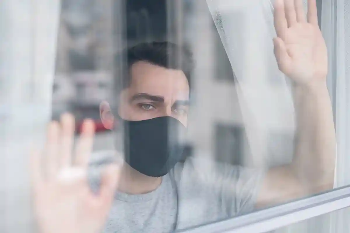 мужчина в маске возле окна