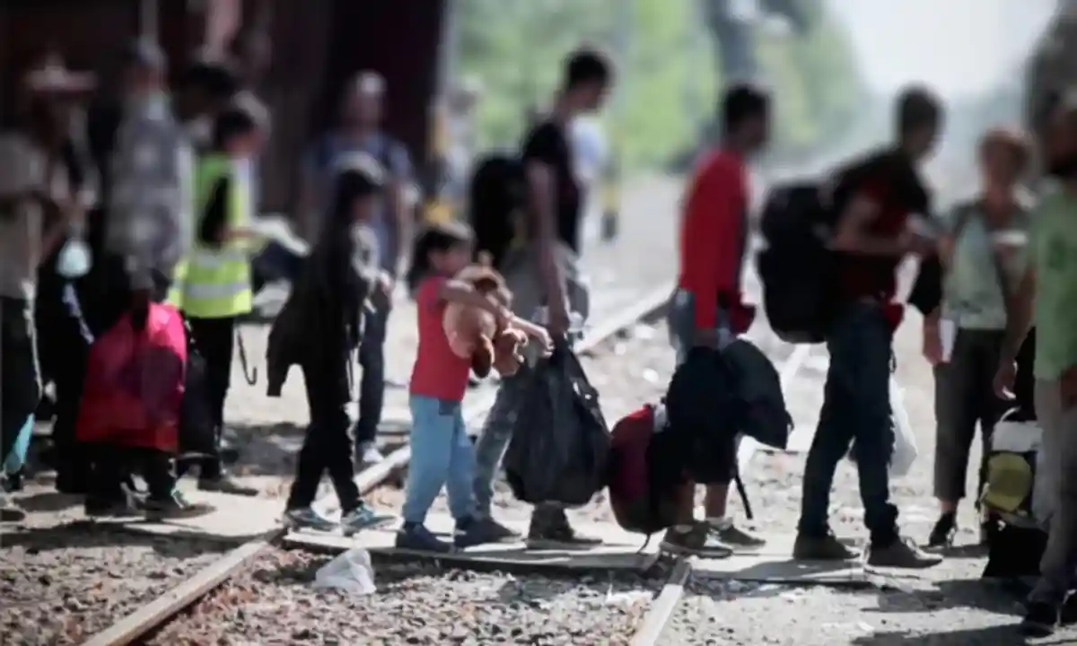 беженцы переходят железнодорожный путь размытое фото