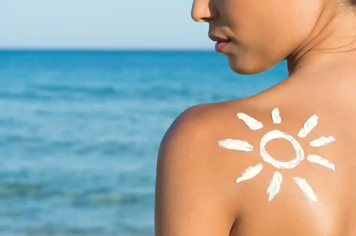 Женщина на пляже с солнцезащитным средством фото