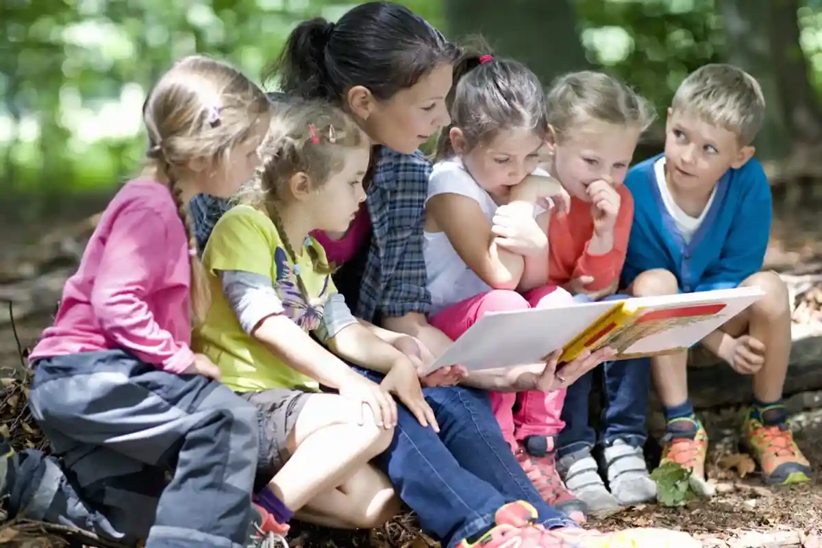 Дети читают на детской площадке фото
