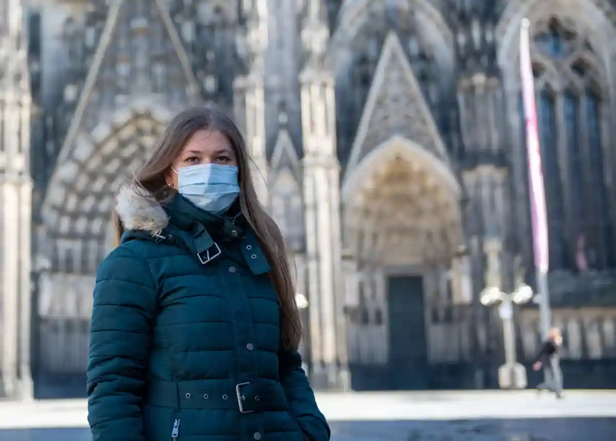 девушка в маске возле собора в Кёльне фото