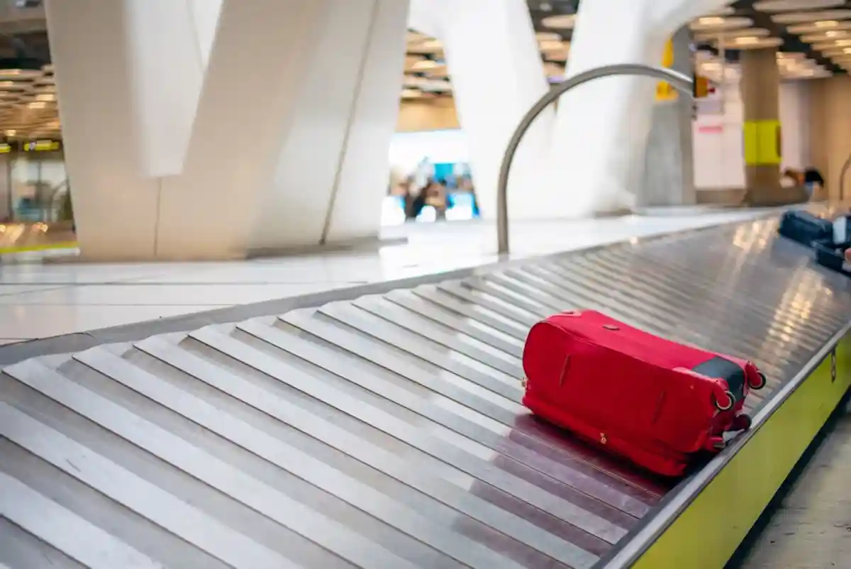 Красный чемодан забытый на ленте в аэропорте фото