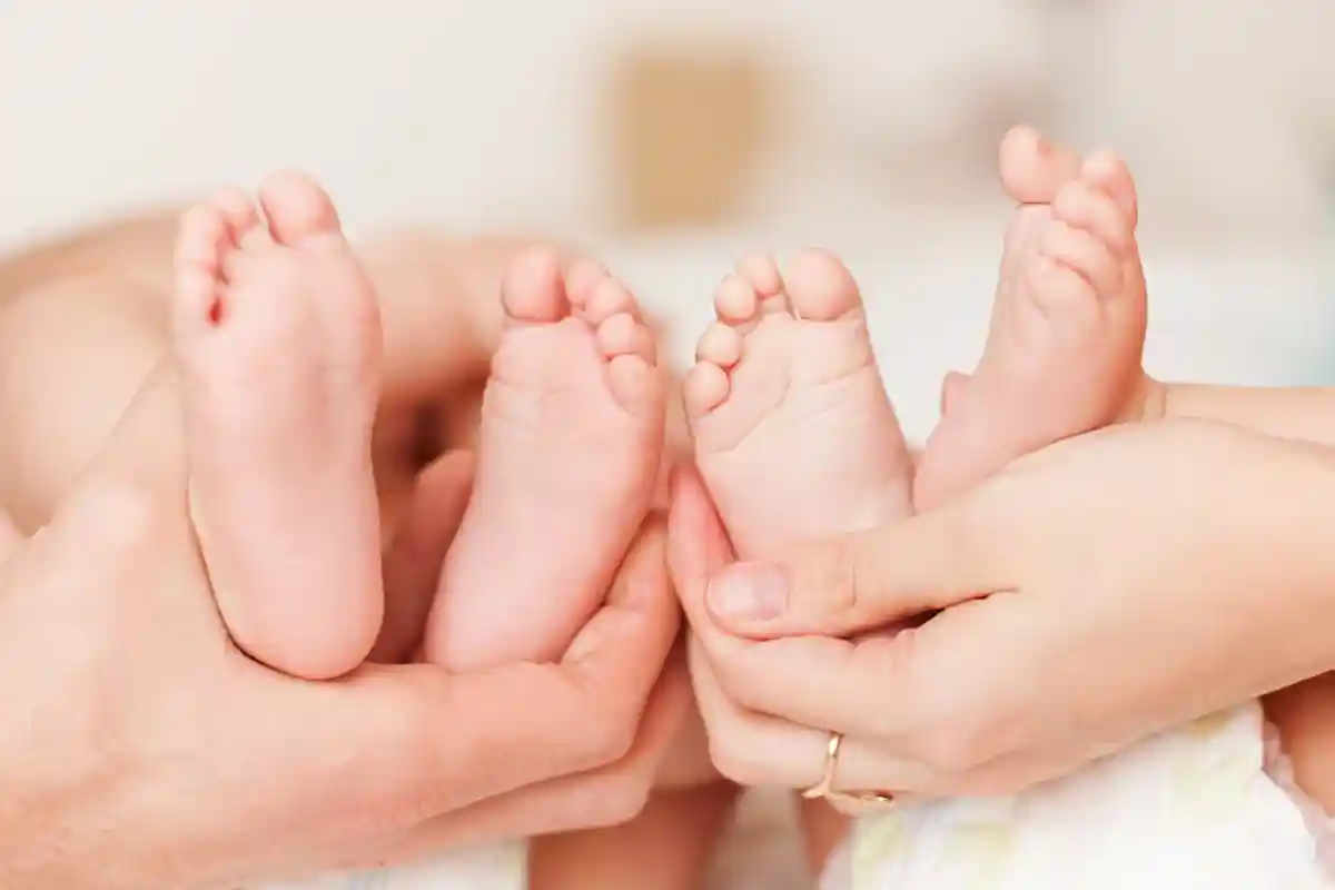 родители держат ножки младенцев фото