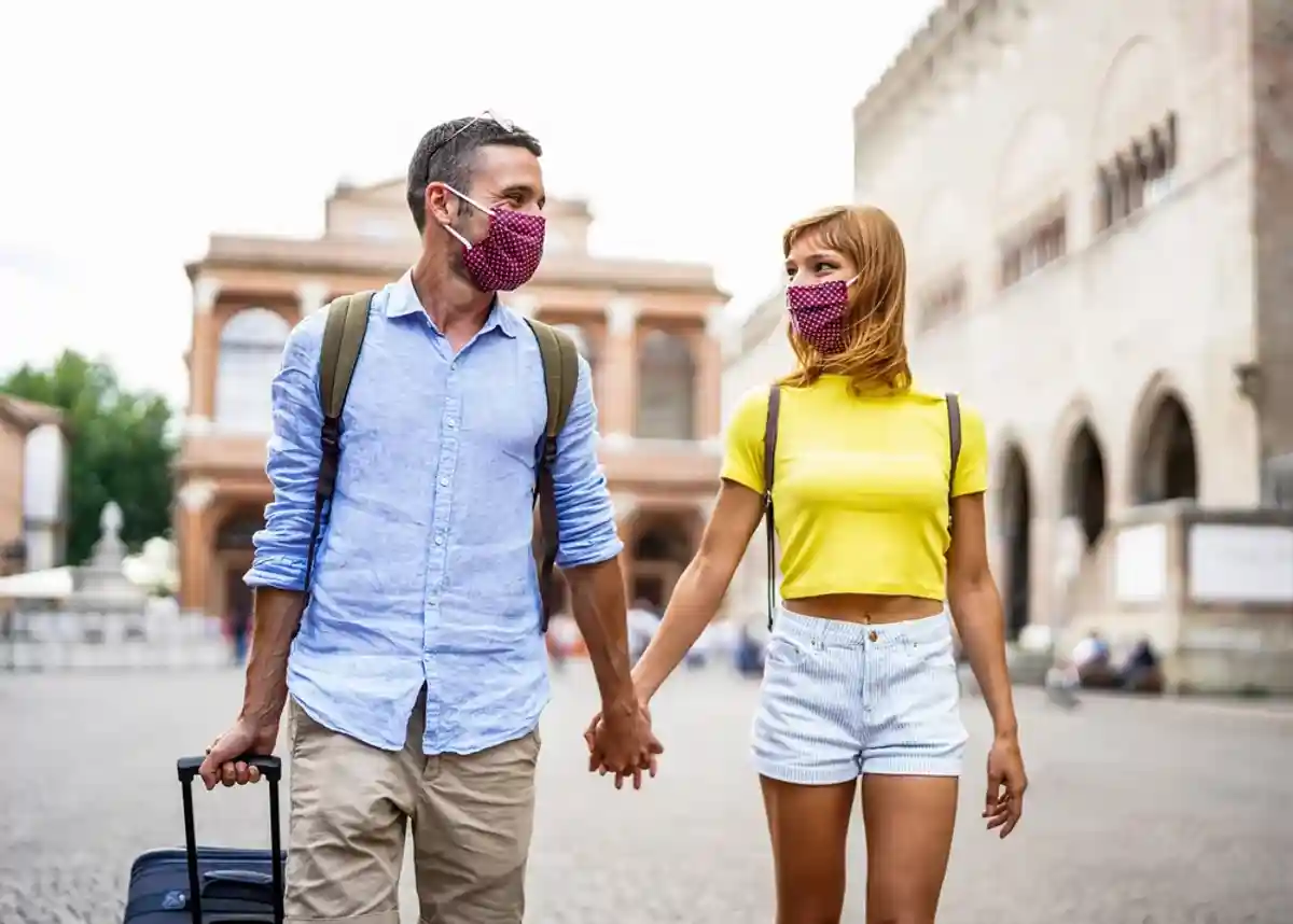 туристы в масках держатся за руки фото