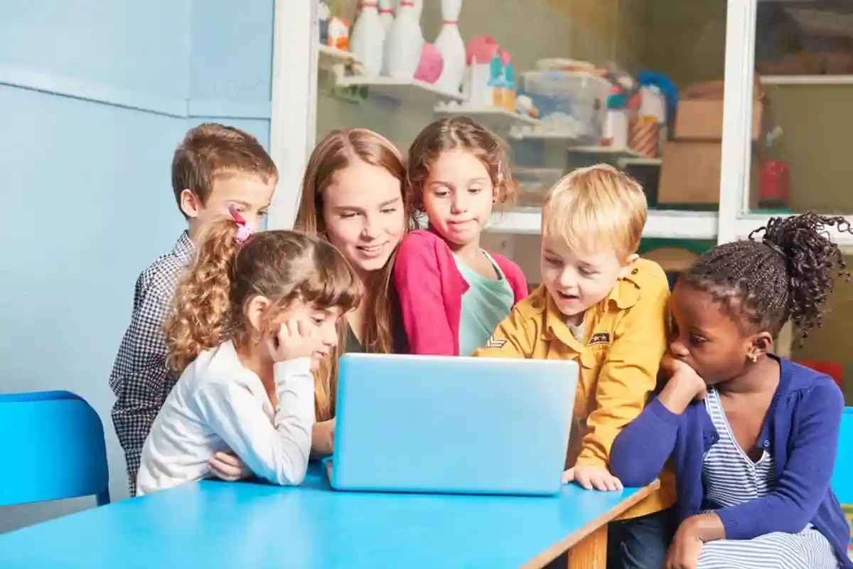 Дети и воспитательница смотрят на монитор компьютера фото