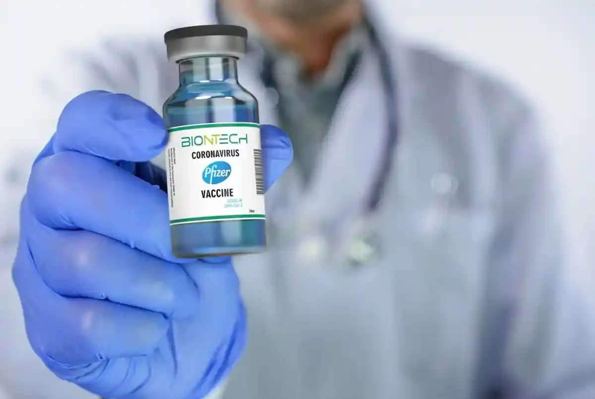 врач держит ампулу с вакциной BioNTech и Pfizer