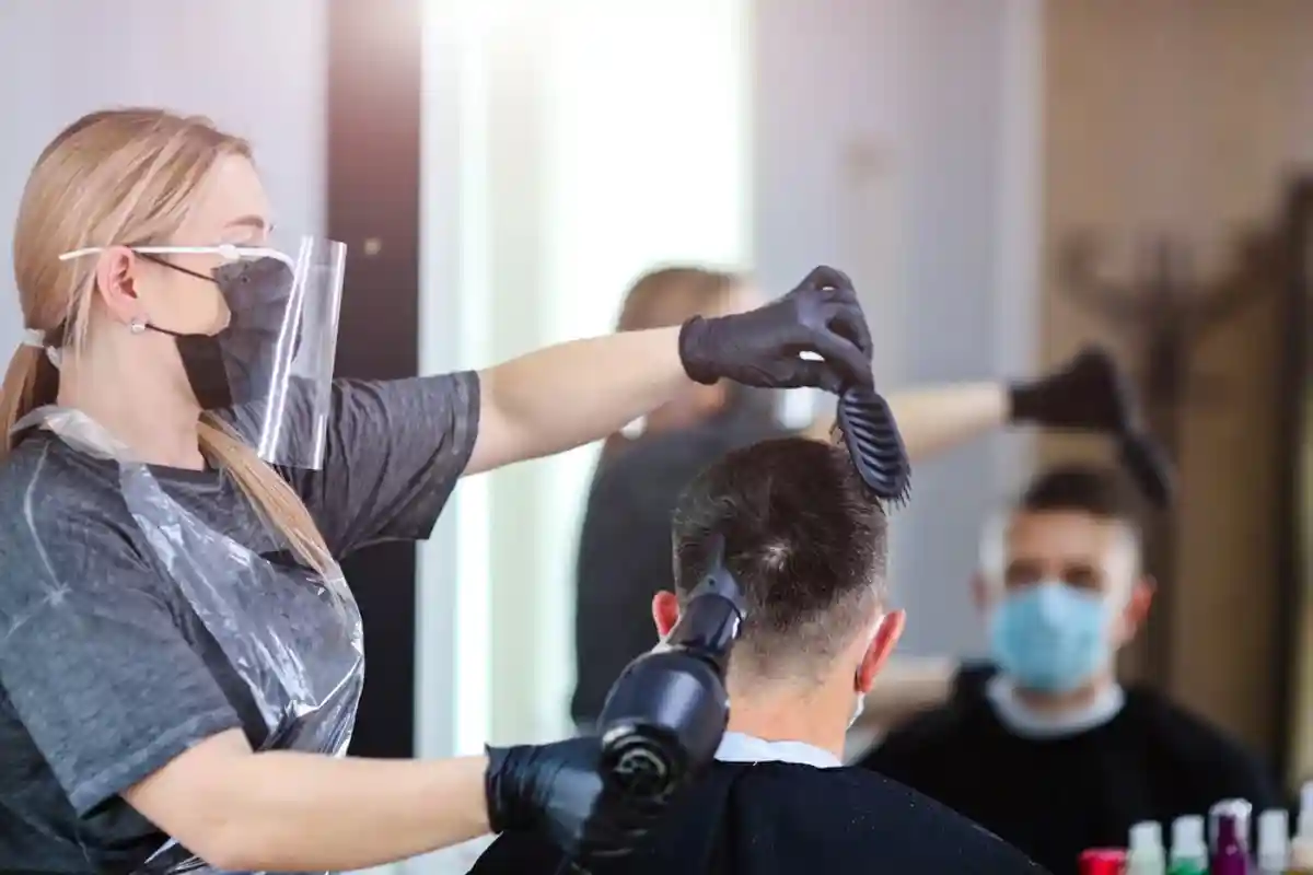 парикмахер в маске делает мужчине укладку фото