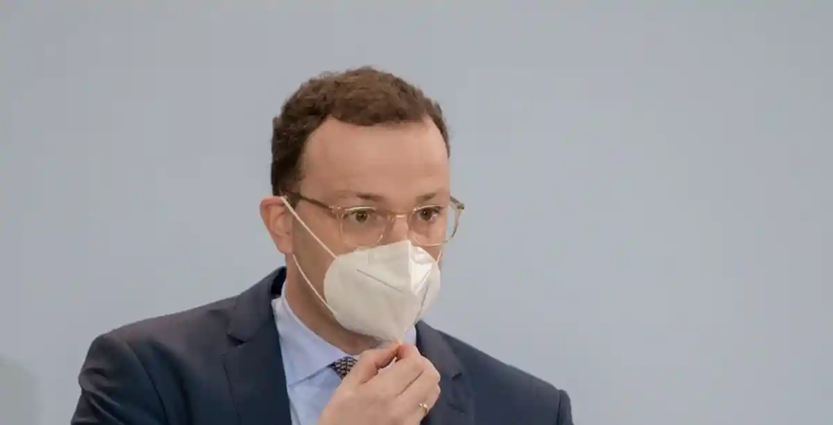 министр здравоохранения Йенс Шпан придерживает маску фото