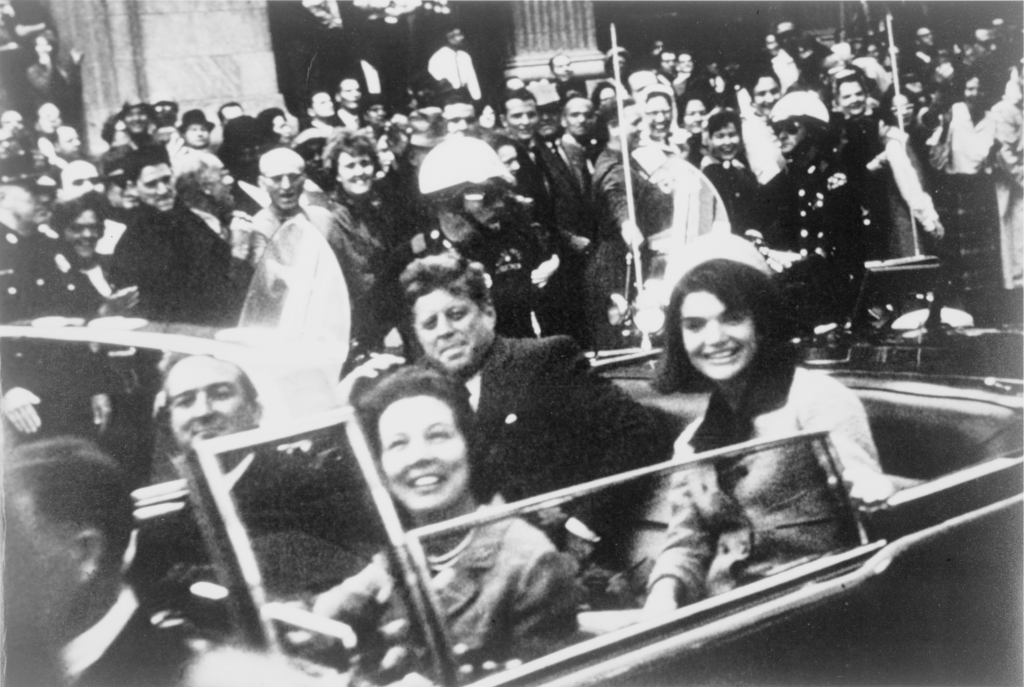 Джон Кеннеди в президентском кортеже, за несколько секунд до убийства. Также в президентском лимузине находятся Джеки Кеннеди, губернатор Техаса Джон Конналли и его жена Нелли. Фото: Victor Hugo King / Wikipedia.org