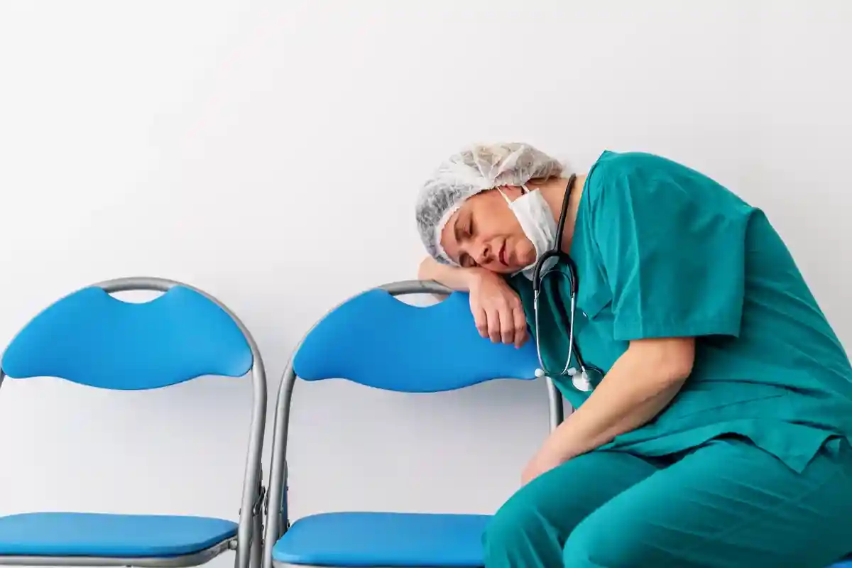 Женщина-врач засыпает на стуле у отделения интенсивной терапии Фото: sondem/Shutterstock.com