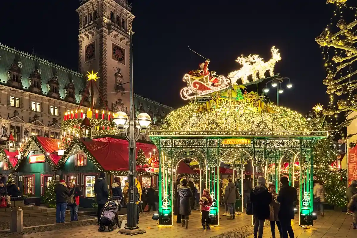 Один из входов на Рождественский рынок перед ратушей Гамбурга в ночное время Фото: Mikhail Markovskiy/Shutterstock.com