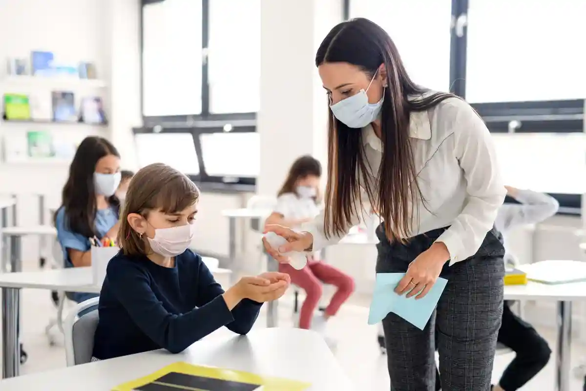 Учитель и дети соблюдают правила по борьбе с коронавирусом Фото: Halfpoint/Shutterstock.com