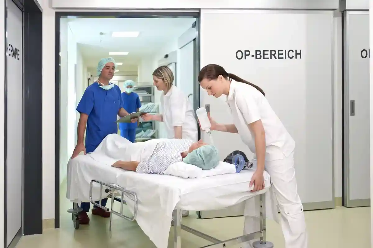 Врач и медсестры принимают пациента в операционную в больнице Фото: Altrendo Images/Shutterstock.com