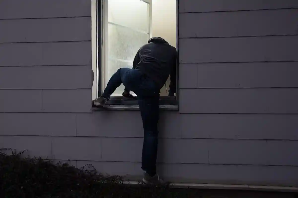 Грабитель влезает в окно Фото: Andrey_Popov/Shutterstock.com