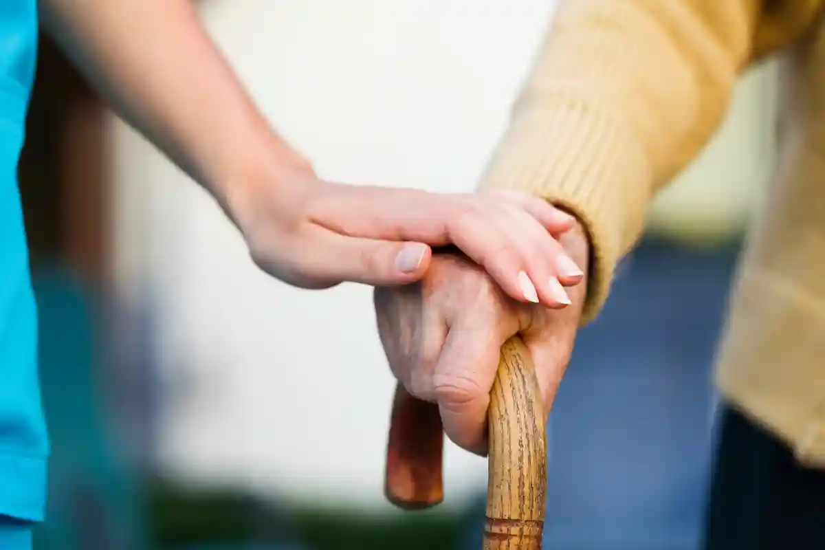 Врач держит руку пожилого пациента на трости Фото: Lighthunter/Shutterstock.com