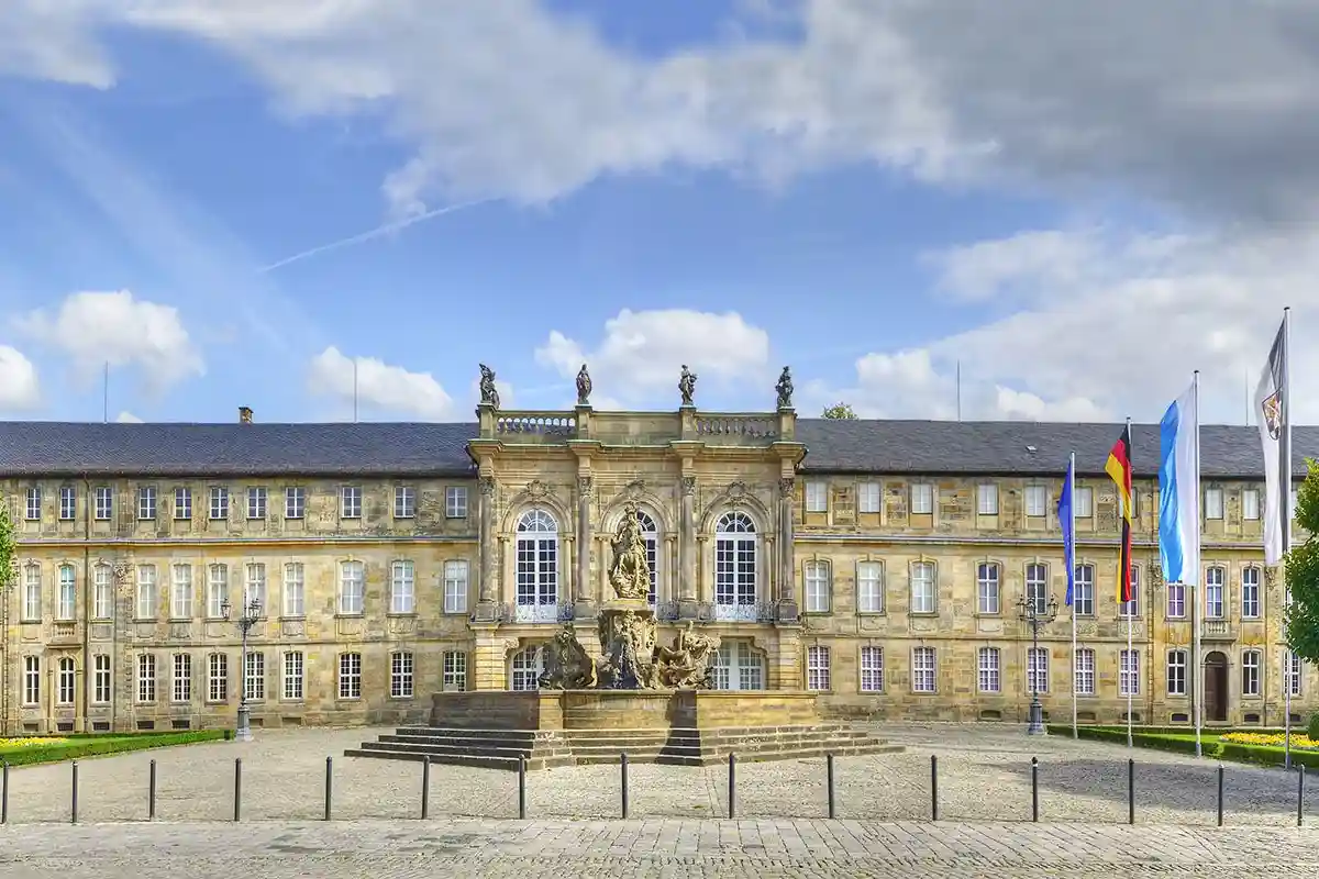 Витиеватый новый замок Neues Schloss с изысканными скульптурами во дворе. Фото Pecold