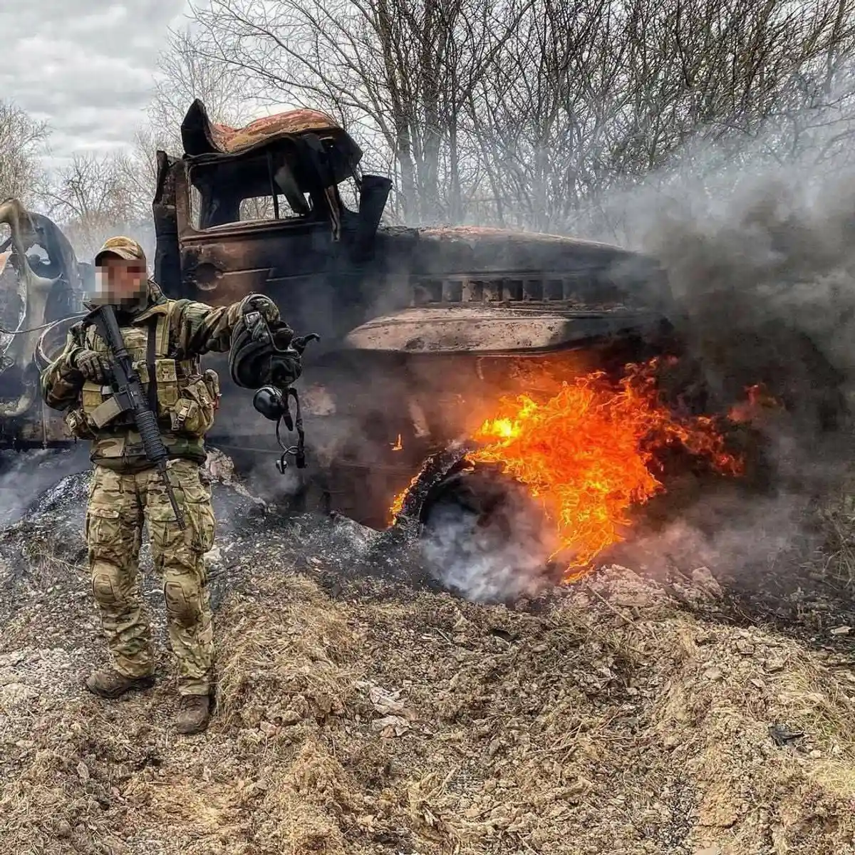Украинский солдат на фоне горящего грузовика российских войск. Фото: t.me/lachentyt