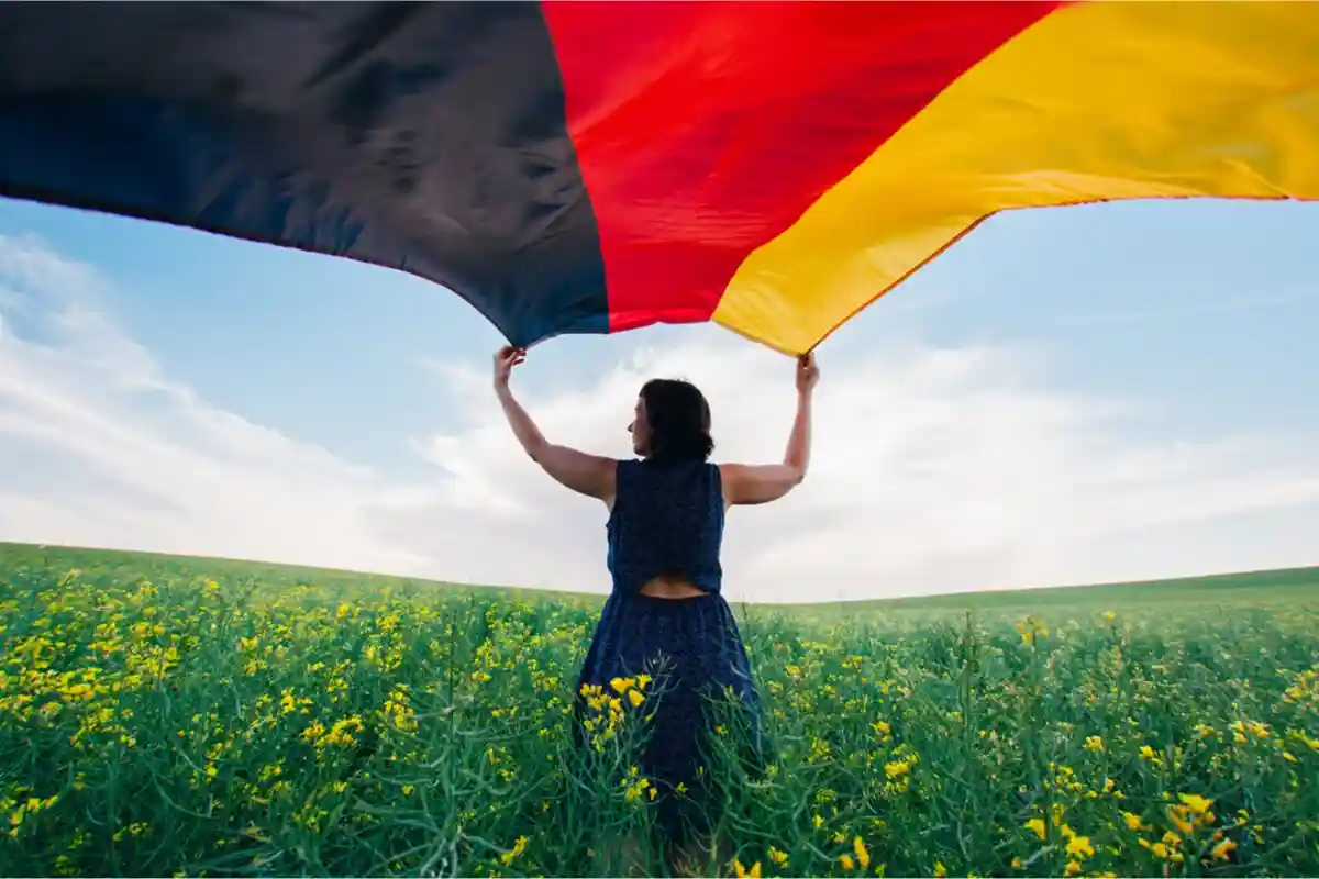 Женщина с флагом Германии. Фото: Angyalosi Beata / Shutterstock.com