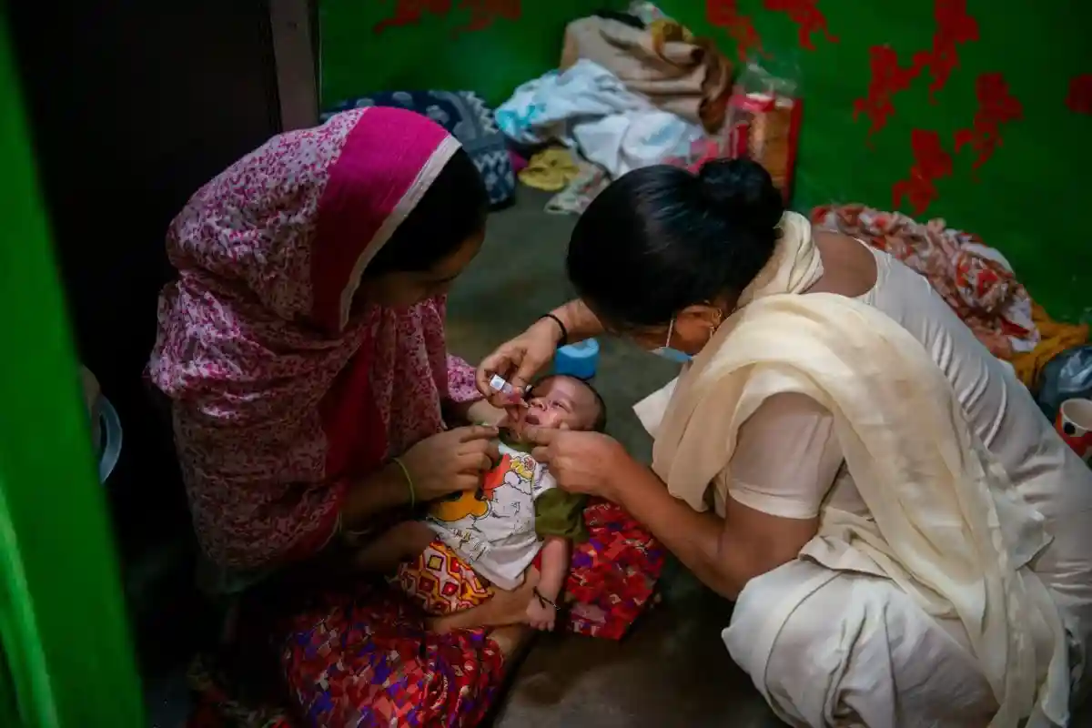  Сотрудница ASHA вводит капли вакцины против полиомиелита ребенку во время национальной программы иммунизации против полиомиелита (ИПВ) в трущобном районе Дели в колонии LNJP. Фото: PradeepGaurs / shutterstock.com