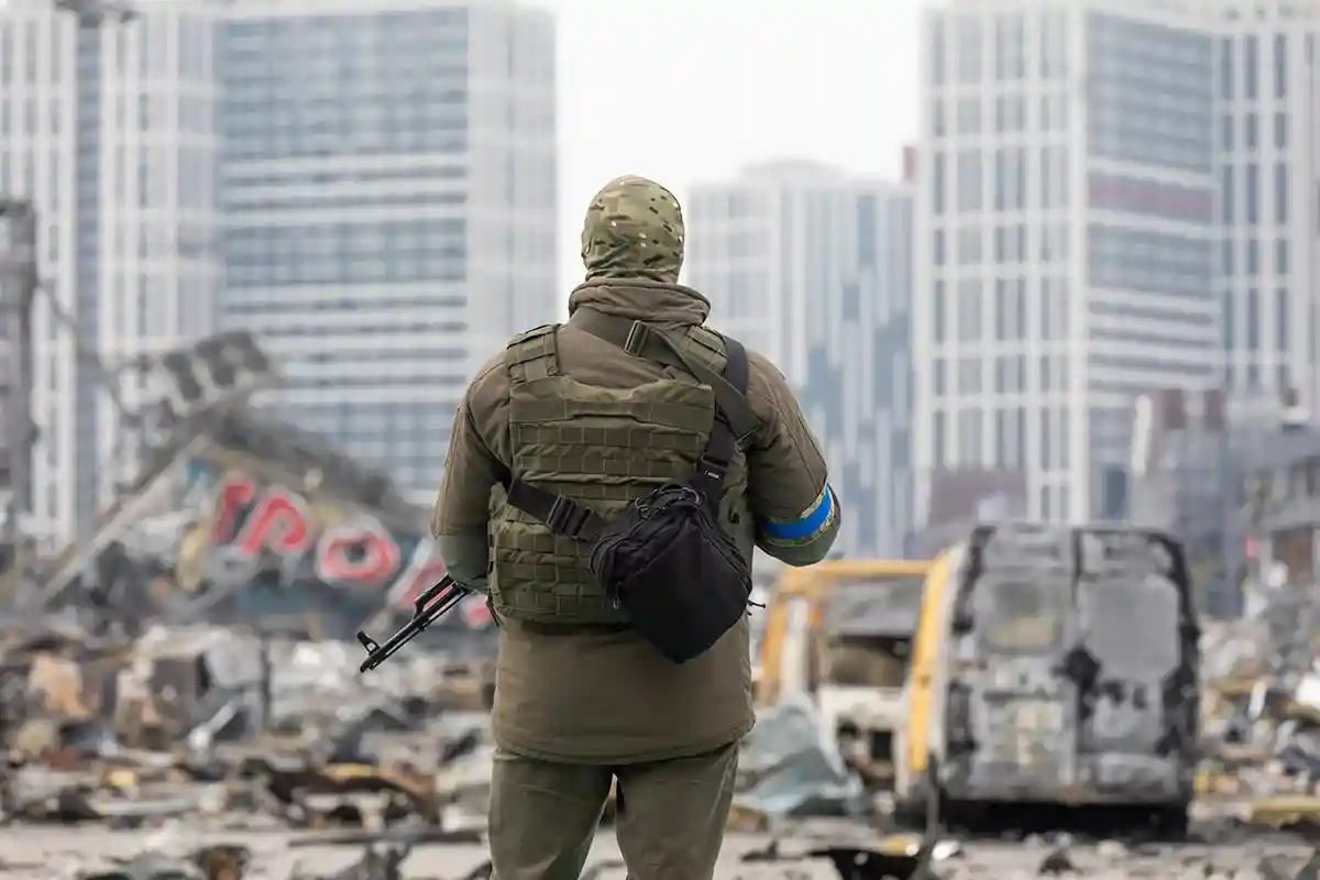 Воин ЗСУ на фоне разрушений после ракетного удара в Киеве. Фото: shutterstock.com