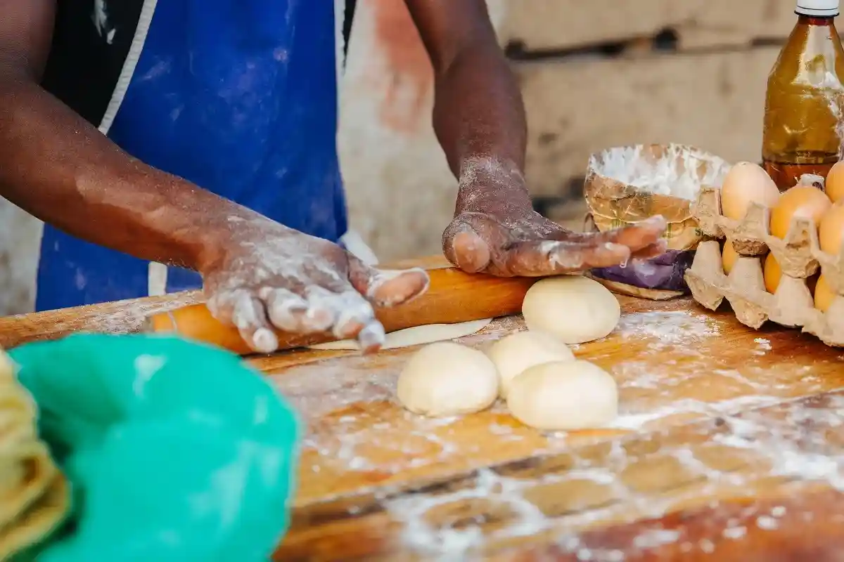 Мужчина из Уганды (Африка) готовит хлеб. Фото: Dennis Diatel / Shutterstock.com)