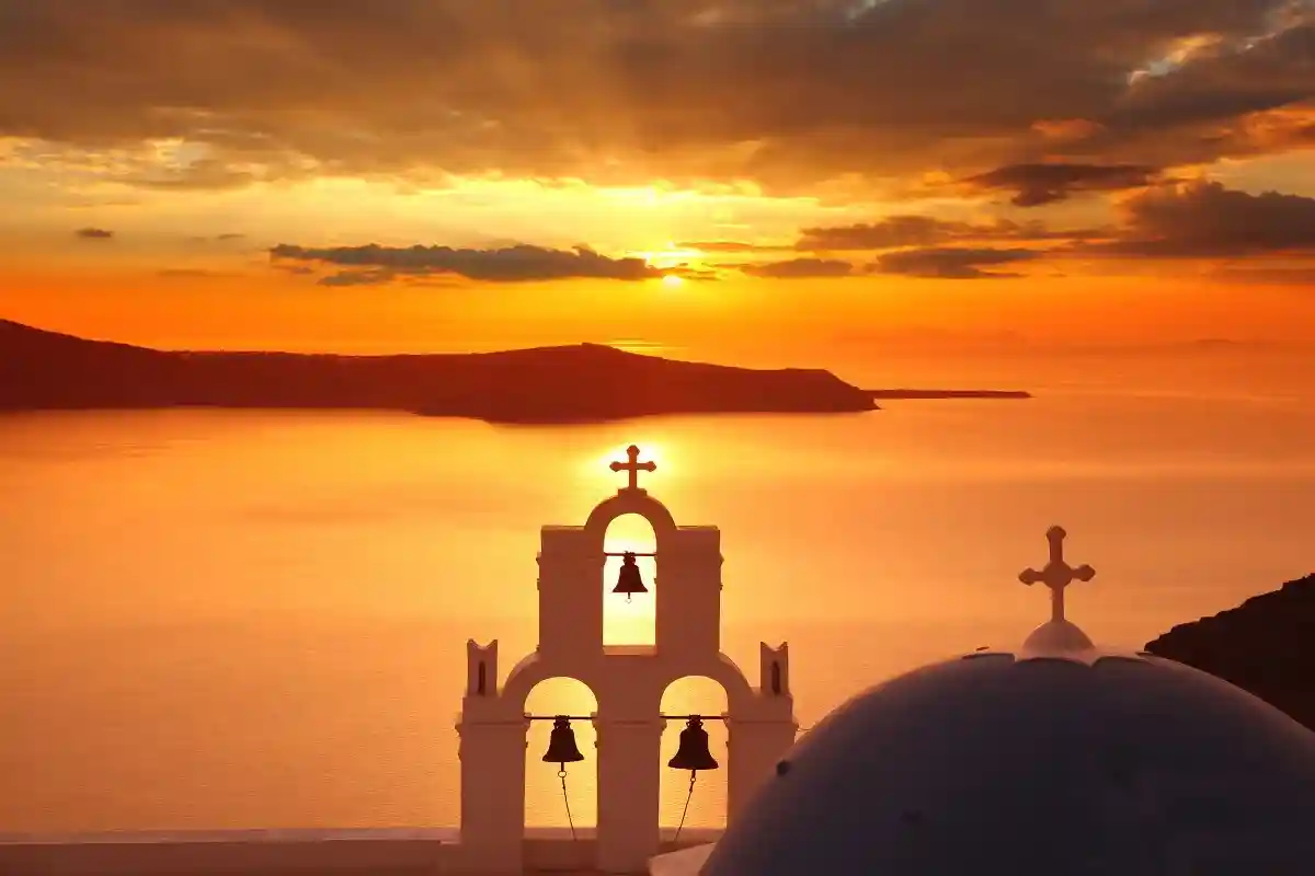 Закат с видом на церковь в Санторини. Фото: Tomas Marek / Shutterstock.com