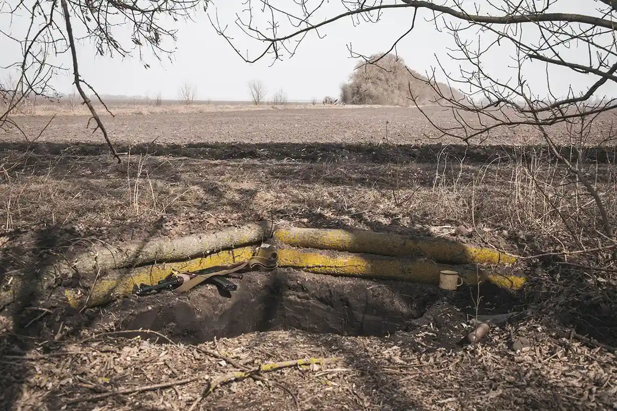 Траншея в земле под деревьями для защиты позиции территориальной обороны во время российско-украинской войны.Фото: shutterstock.com