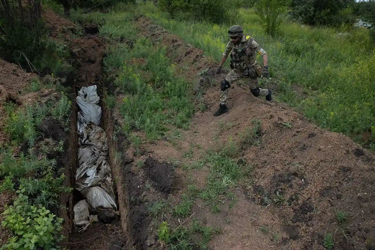 Украинский солдат у братской могилы на холмах над Лисичанском. Фото: Tyler Hicks