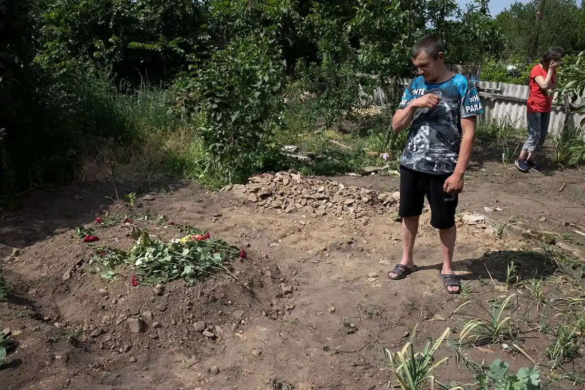 Максим Катеринин в этом месяце в Лисичанске рядом с могилой своей матери, погибшей от российского обстрела из миномета. Фото: Tyler Hicks