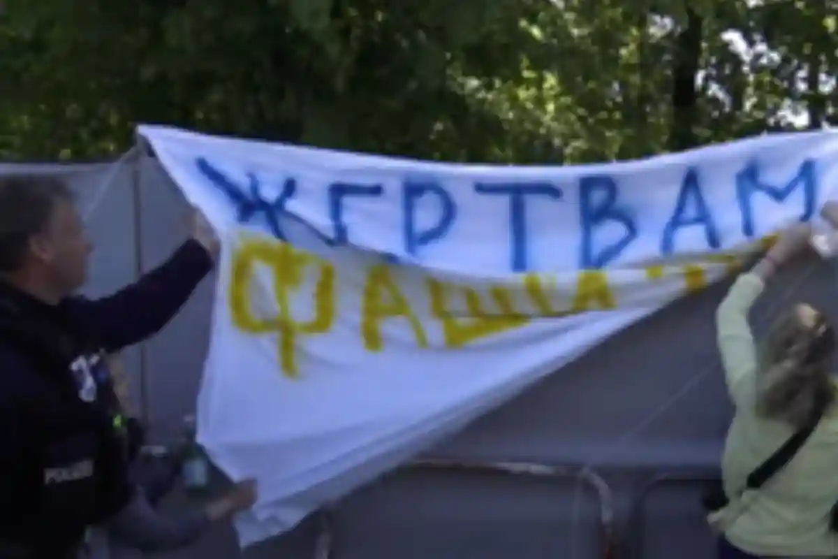 Флаг "Жертвам Фашизма" снимают. Русские активисты требуют извинений от полиции Берлина за снятый флаг. Фото: "Демократы-Я".