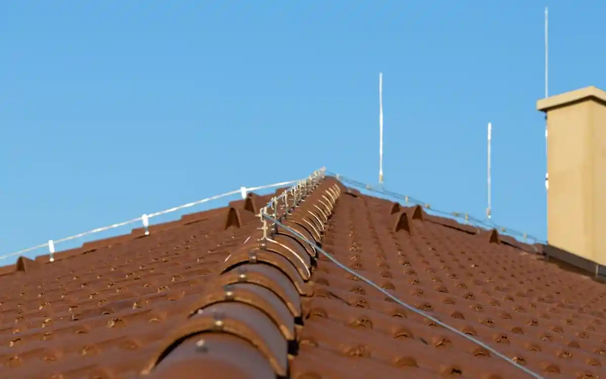 Молниезащита на крыше дома. Это штырь, сетка либо трос, «встречающий» разряд молнии на крыше и принимающий удар на себя. Фото: Shutterstock