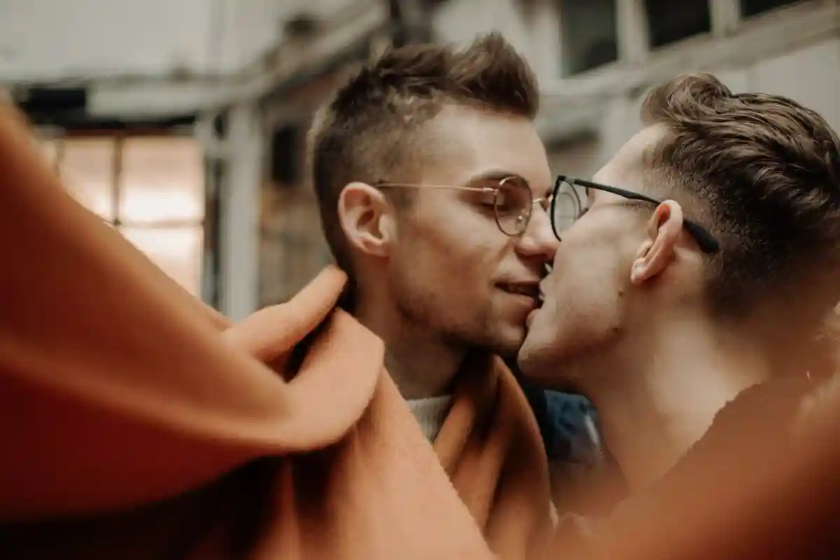 Парень целует парня. Гомофобия все еще существует в германии. Фото: Renate Vanaga / Unsplash.com