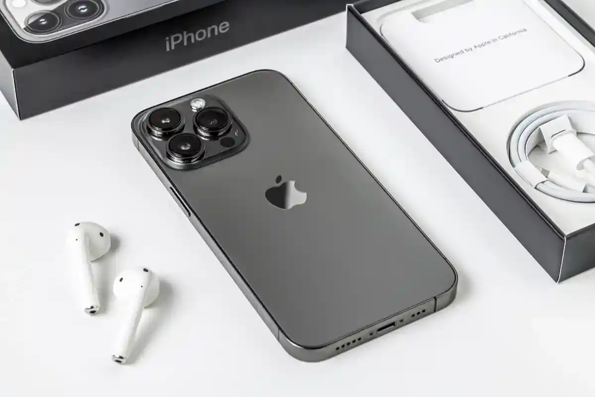 Вид сзади смартфона iPhone 13 Pro и наушников Apple Airpods 2. Фото: Yalcin Sonat / Shutterstock.com