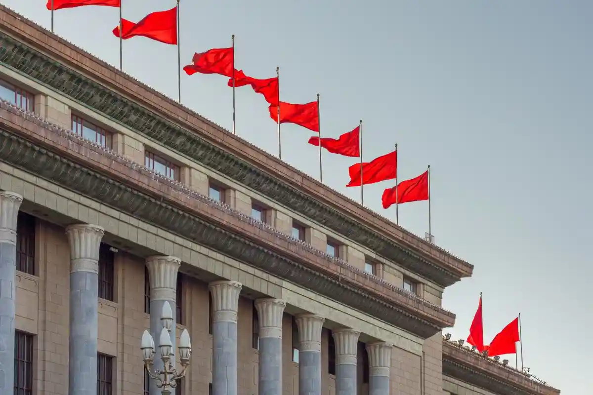 Красные флаги на Доме народных собраний. Фото: Mirko Kuzmanovic / Shutterstock.com