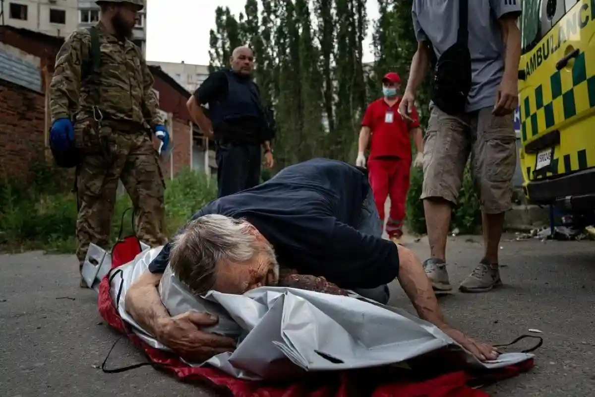 На этом фото Харьков. Мужчина обнимает тело своей жены, которая вышла в магазин и погибла от снаряда. Фото: Евгений Малолетка / instagram.com