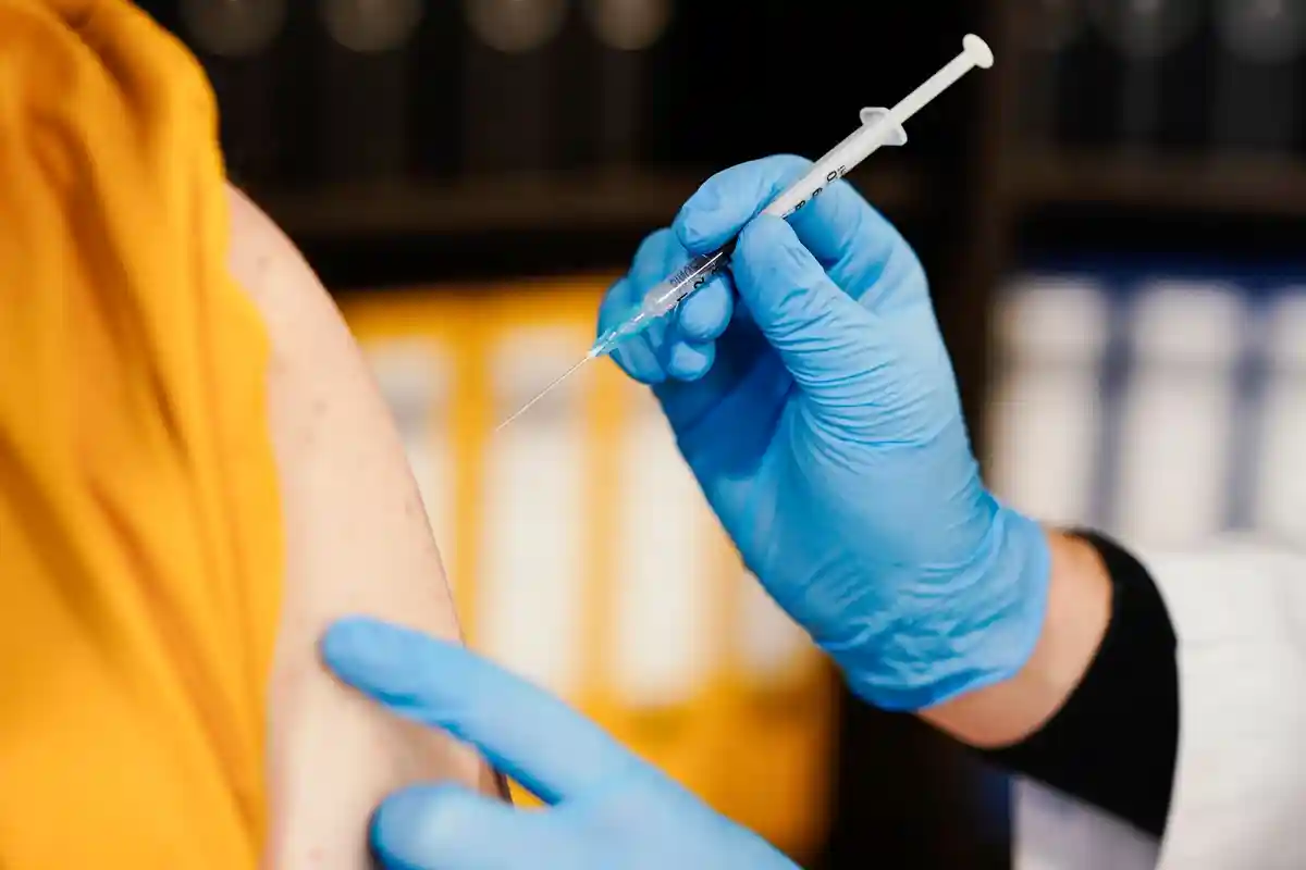 Фармацевт прививает мужчине прививку от Короны