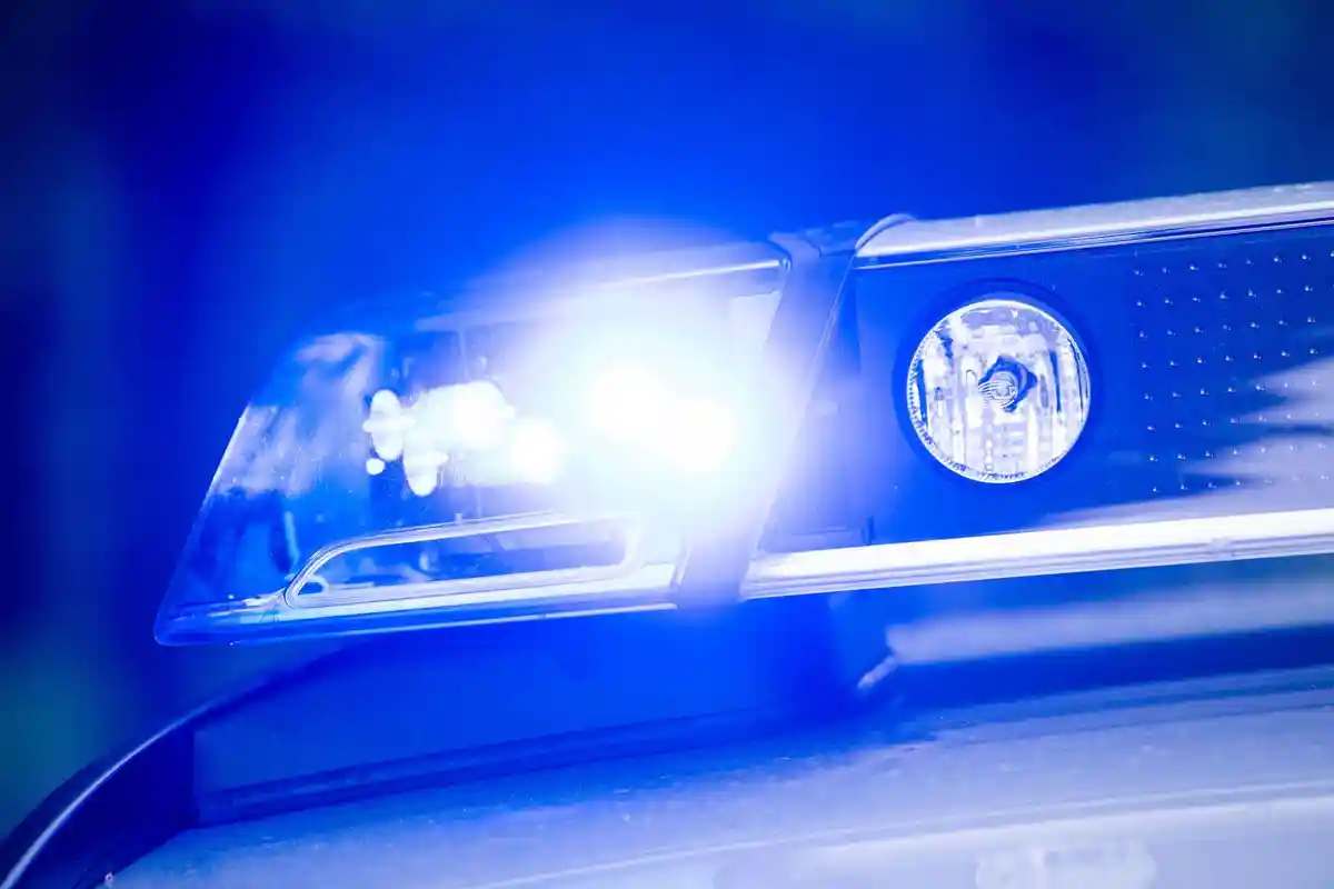 На крыше полицейской патрульной машины светит синий фонарь
