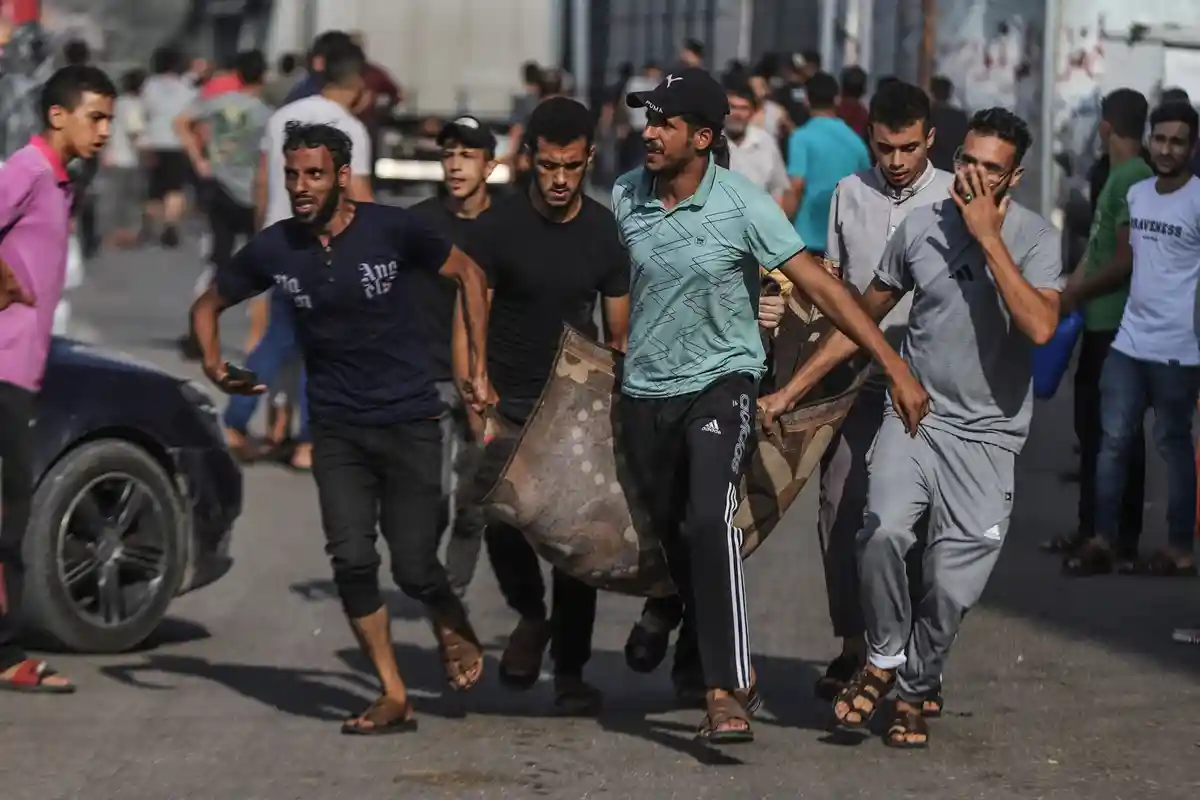 Ближневосточный конфликт - Сектор Газа:Палестинцы транспортируют раненого после израильского авиаудара по городу Газа.