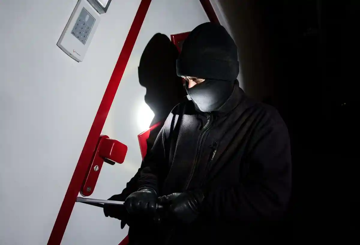 Число квартирных краж растет:Мужчина, переодетый во взломщика, вскрывает дверь в Центре консультирования по вопросам уголовного розыска (кадр).