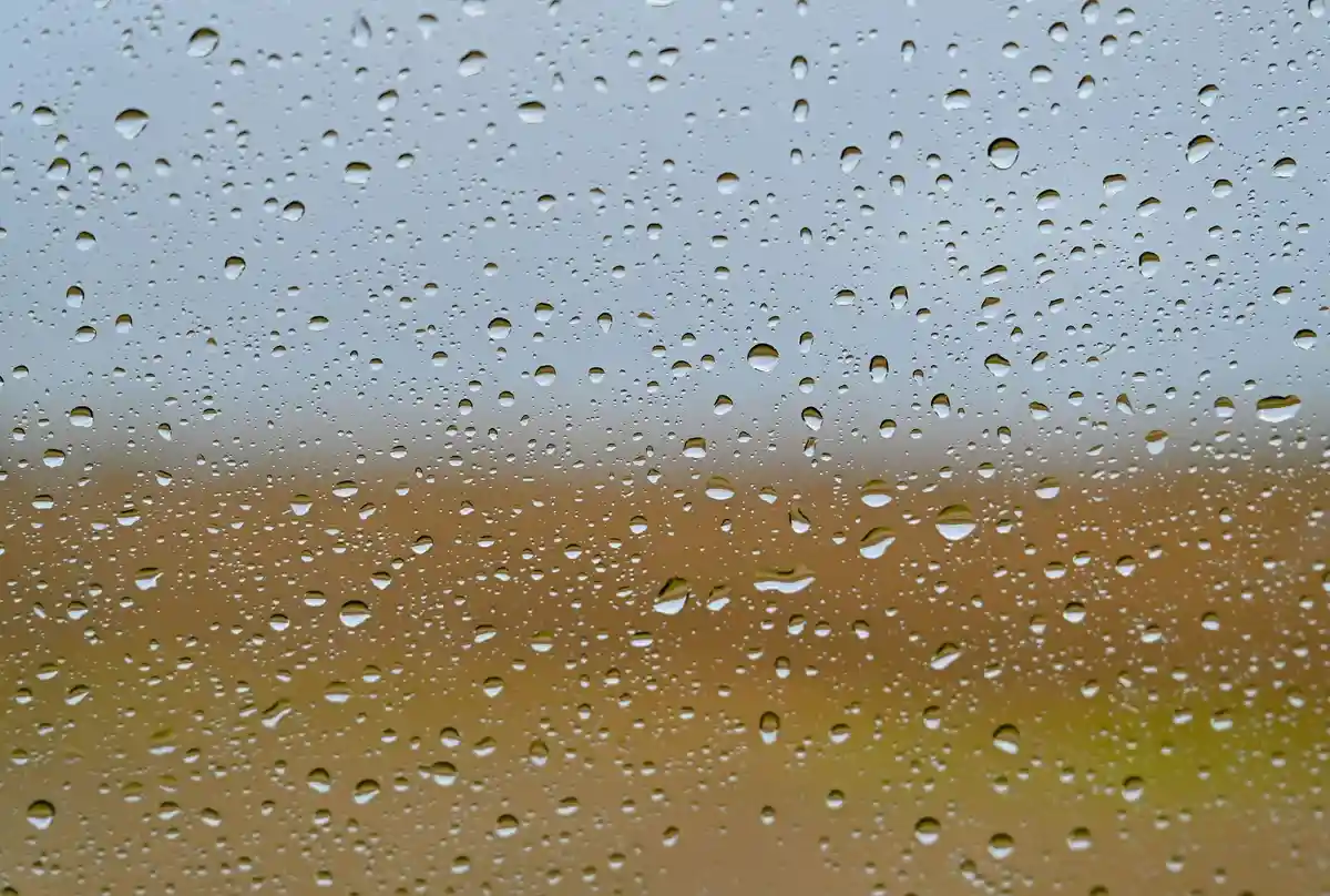 Дождливая погода:Капли воды видны на стекле автомобиля после дождя.