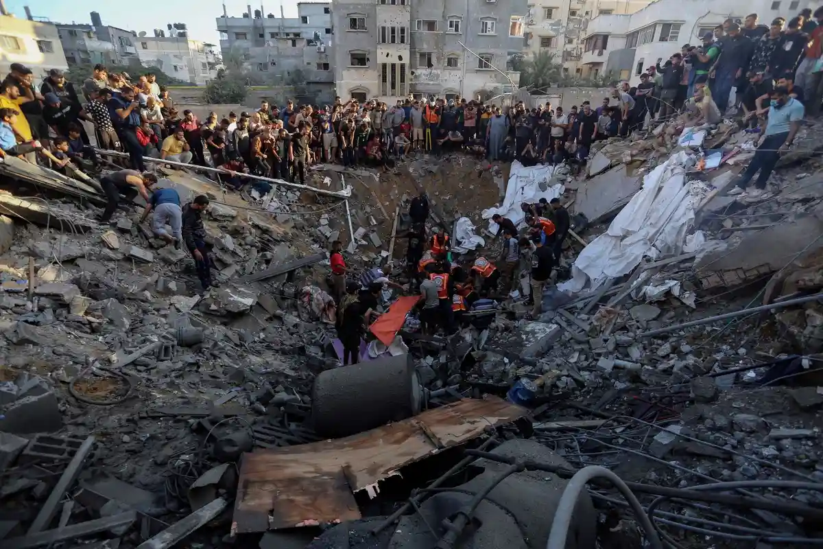 Город Газа:Палестинцы собираются у остатков разрушенного дома в городе Газа.