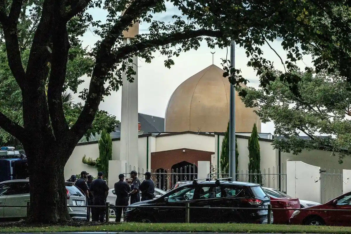 Крайстчерч:Сотрудники полиции стоят у одной из двух мечетей в Крайстчерче на следующий день после преступления, когда правый экстремист застрелил 51 человека и ранил еще 50.