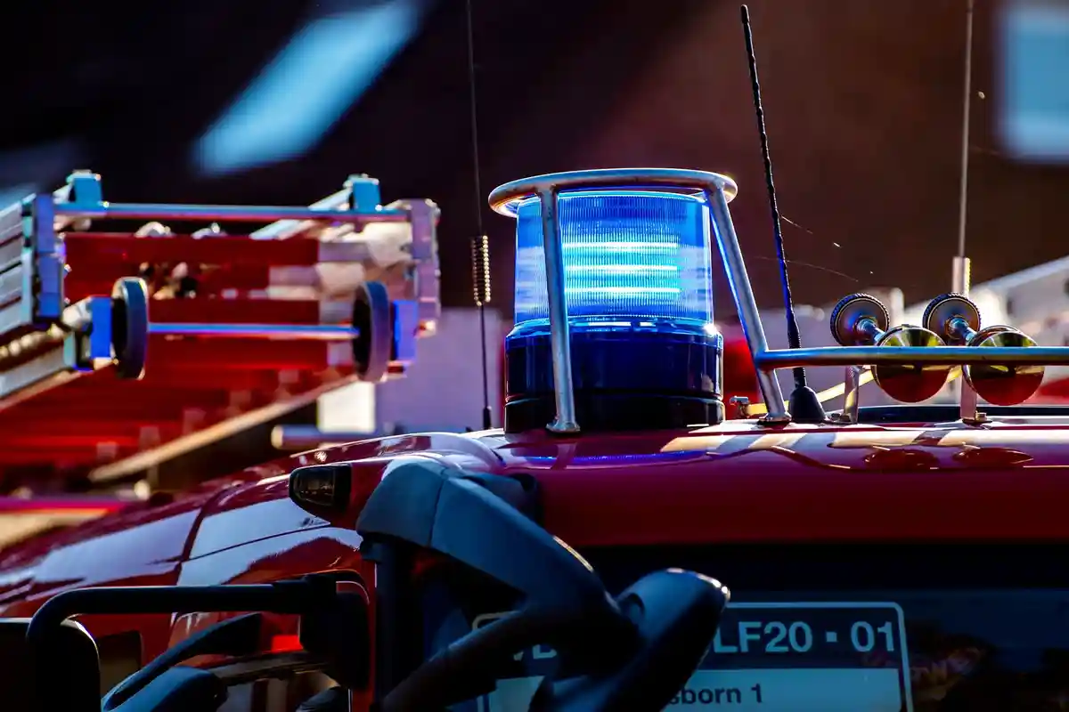 На крыше аварийного автомобиля светится синий фонарь:Синий свет освещает крышу аварийного автомобиля пожарной бригады.