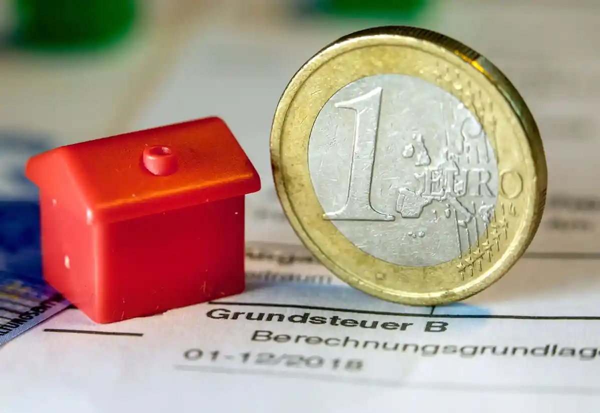 Налоговые декларации по налогу на имущество:Монета евро и игрушечный домик находятся в извещении об уплате налога на имущество.
