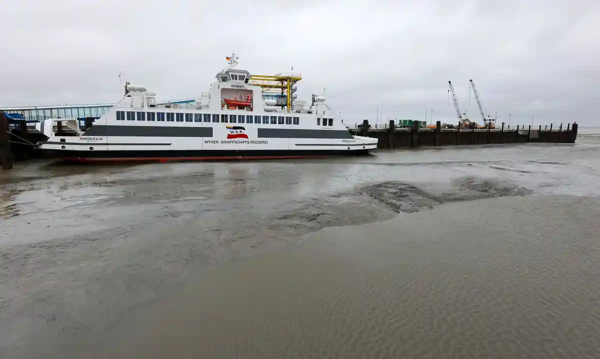 Паромное сообщение приостановлено из-за низкого уровня воды:Паром Norderaue компании Wyker Dampfschiffs-Reederei Föhr-Amrum лежит в почти пустом портовом бассейне у причала.