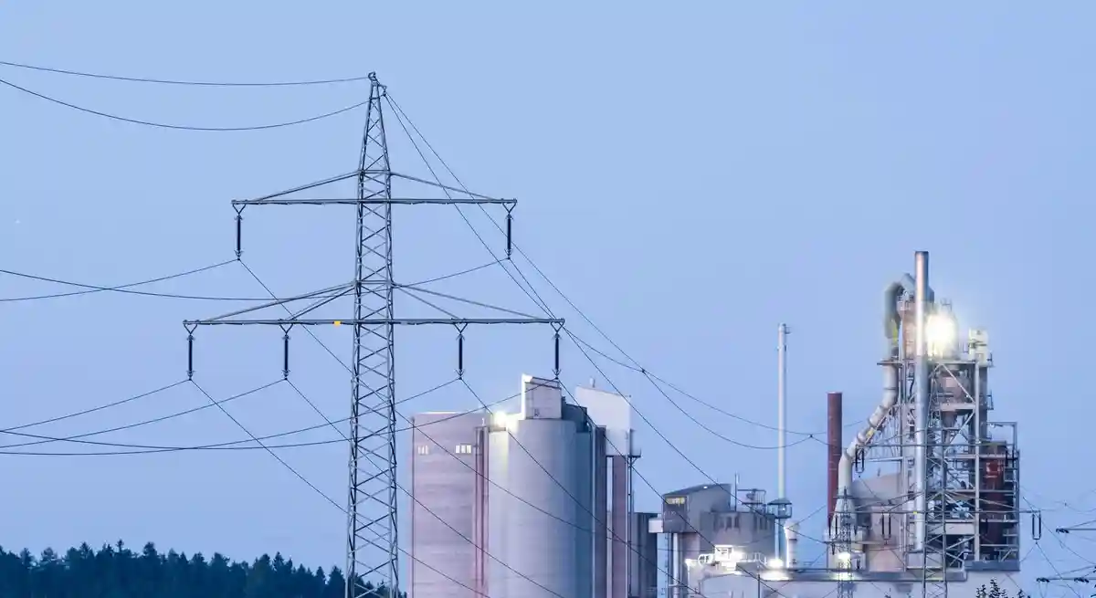 Цена на электроэнергию для промышленности:Опоры электропередач в утреннем свете перед цементным заводом в Роттвайле.