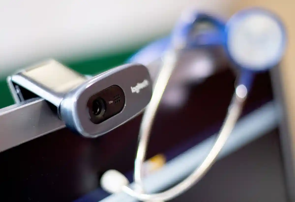 Видеоконсультация:Веб-камера и стетоскоп находятся в кабинете врача рядом с компьютером во время видеоконсультации.