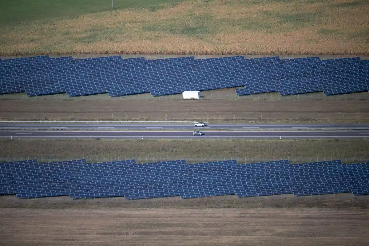 Парк солнечных батарей на трассе A24:Солнечные батареи установлены рядом с дорогой.