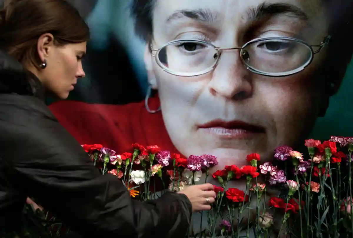 Дело об убийстве Политковской:Женщина возлагает цветы к портрету убитой российской журналистки Анны Политковской в Москве.